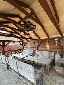 a patio with wooden tables and benches and a chandelier at Jedlinka in Palota +69 photos