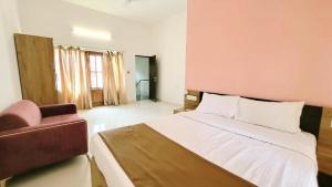 a bedroom with a large bed and a chair at 4 BHK villa with private Jacuzzi & Shared pool- Anjuna in Anjuna +33 photos