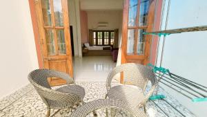 a balcony with two chairs and an open door at 4 BHK villa with private Jacuzzi & Shared pool- Anjuna in Anjuna