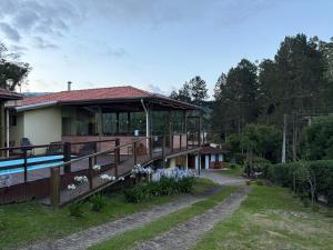 a house with a deck and a swimming pool at Pousada São Miguel Natureza e Descanso em Cunha SP in Cunha