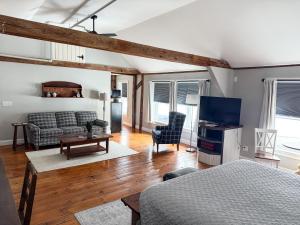 a room with a bed and a couch and a tv at The Black Walnut Inn in Amherst