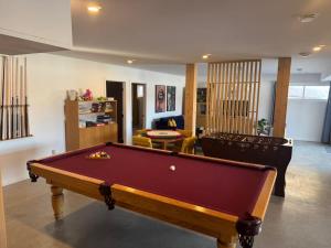 a living room with a pool table in it at Lakeview Mid Century Luxury Cottage in Sainte-Adèle