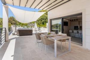 a dining area with a table and chairs on a patio at Sea View House with Jacuzzi - Casa Bianca Brač in Selca