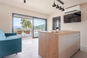 a kitchen with a island with a view of the ocean at Sea View House with Jacuzzi - Casa Bianca Brač in Selca