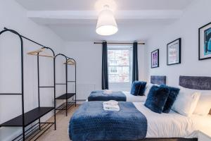 a bedroom with two beds with blue pillows at 15A Well Street in Ruthin