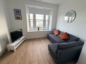 a living room with a couch and a television at 2 Bed Apartment with Harbour Views Apt 2 in Cobh
