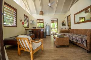 a living room with a couch and a table at Whispering Palms - Absolute Beachfront Villas in Port Vila