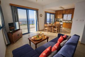 a living room with a blue couch and a table at Livia - Vikles Villas in Pomos