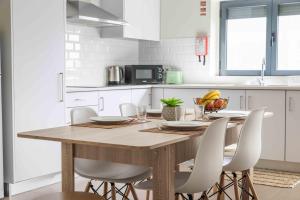 a kitchen with a wooden table and white cabinets at Olive House in Fátima +14 photos