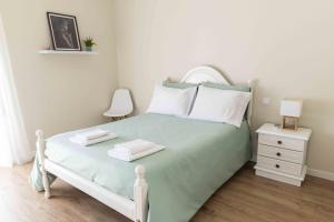 a bedroom with a bed and a nightstand with two towels at Olive House in Fátima