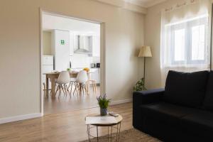 a living room with a black couch and a table at Olive House in Fátima