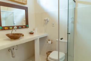 a bathroom with a sink and a toilet and a mirror at Rio Da Barra Villa Hotel in Trancoso +163 photos