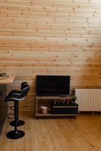 a living room with a black chair in front of a television at Lumina Cottage in Gudauri
