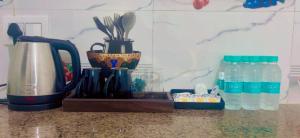 a kitchen counter with a coffee maker and bottles of water at The Velvet Nest - Gurgaon - Luxurious Single Bedroom Private Villa with Garden in Gurgaon