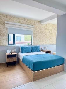a bedroom with a bed with blue sheets and a window at Dreamer Beach Club in San Andrés