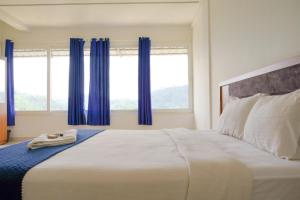 a bedroom with a large bed with blue curtains at Vythiri Palace Wayanad Pool Resort - Mist Climate & India's First Apple Infinity Pool in Vythiri