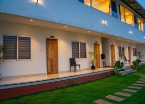 a house with a lawn in front of it at Vythiri Palace Wayanad Pool Resort - Mist Climate & India's First Apple Infinity Pool in Vythiri