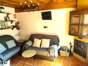 a living room with a couch and a tv at Casa rural Angelita in Cangas de Onís