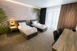 a hotel room with two beds and a table at Hotel Oasis in Vinnytsya +28 photos
