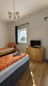 a bedroom with two beds and a flat screen tv at Pension Horvath in Sankt Kanzian