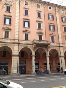 een roze gebouw met bogen en fietsen voor het gebouw bij Decorialab Apartments in Bologna