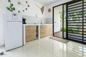 a kitchen with white appliances and a large window at Fare Re'are'a - Charmant bungalow côté mer proche de la plage de Temae in Moorea +32 photos