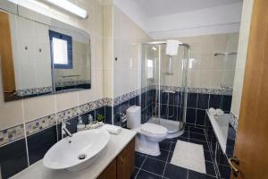 a bathroom with a sink and a toilet and a shower at Livia - Vikles Villas in Pomos +27 photos