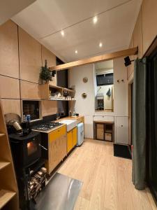 a large kitchen with wooden flooring and yellow appliances at La Tiny De Fy in Aywaille