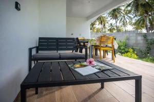 a black table with a plate of food on it at Fare Re'are'a - Charmant bungalow côté mer proche de la plage de Temae in Moorea