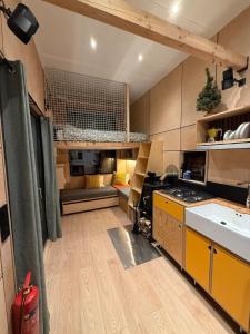 a kitchen with yellow cabinets and a stove top oven at La Tiny De Fy in Aywaille +5 photos