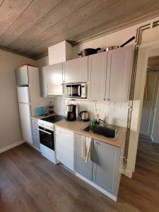 a kitchen with white cabinets and a sink at Majoitus Merihelmi in Kristinestad