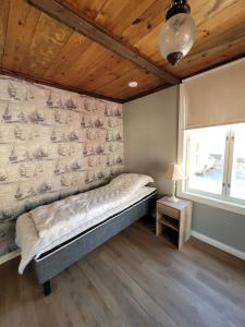 a bedroom with a bed in a room with a wall at Majoitus Merihelmi in Kristinestad