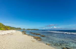 a beach with rocks in the water on a clear day at Fare Re'are'a - Charmant bungalow côté mer proche de la plage de Temae in Moorea