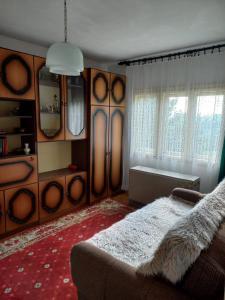 a bedroom with a bed and a couch and windows at Domaćinstvo Simović in Duboko