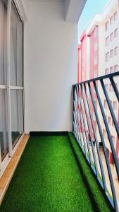 a balcony with green flooring in a building at Modern 3BR Apt with Pool within UN-Approved Zone, Kiambu Rd in Nairobi