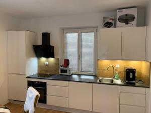 a kitchen with white cabinets and a sink at Ferienhaus Krenn in Bad Gleichenberg +1 photo