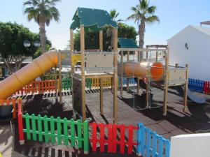een speeltuin met een glijbaan in een park bij Playa Flamingo B in Playa Blanca