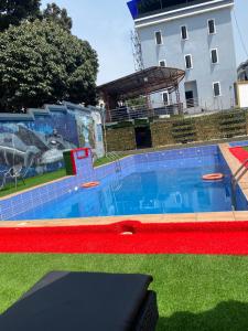 a large swimming pool in front of a building at Bluespring luxury hotel in Elu +7 photos