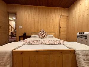 a large bed in a room with wooden walls at Favela Headrooms in Srinagar