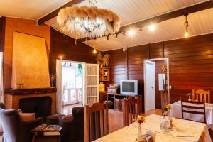 a living room with a table and a fireplace at Pousada do Vento in Campos do Jordão