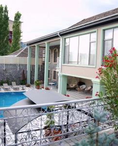a balcony with a table and a swimming pool at Comfort Villa Sheki in Sheki
