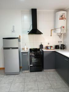 a kitchen with a refrigerator and a stove top oven at Confort urbano - Departamento de 1 dormitorio con cochera in Venado Tuerto
