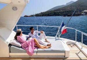 a man and woman sitting on the back of a boat at Private Yacht Monaco in Monte Carlo