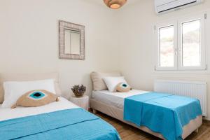 a bedroom with two beds with blue sheets at Sarris Village Luxury 2 in Sarakíniko
