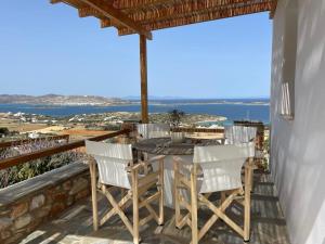 a table and chairs on a balcony with a view of the ocean at Sarris Village Luxury 2 in Sarakíniko