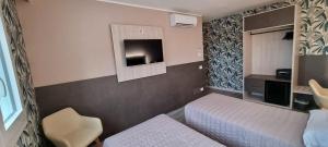 a small bedroom with two beds and a tv at Art Hotel Udine in Udine +29 photos
