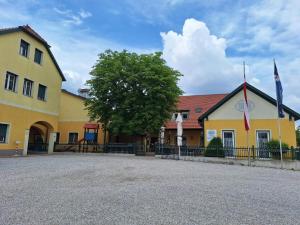 a yellow building with two flags in front of it at Ferienwohnung Traismauer TOP 2 in Wagram an der Traisen