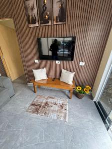 a living room with a wooden table and a tv at Edicula para temporada in Piracicaba