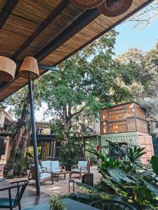 a patio with tables and chairs and a tree at OBOĒ Gardenstē in Pereybere