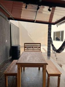 a wooden table and hammock on a patio at Edicula para temporada in Piracicaba